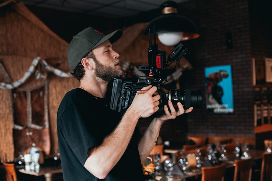 man filming a video in a bar
